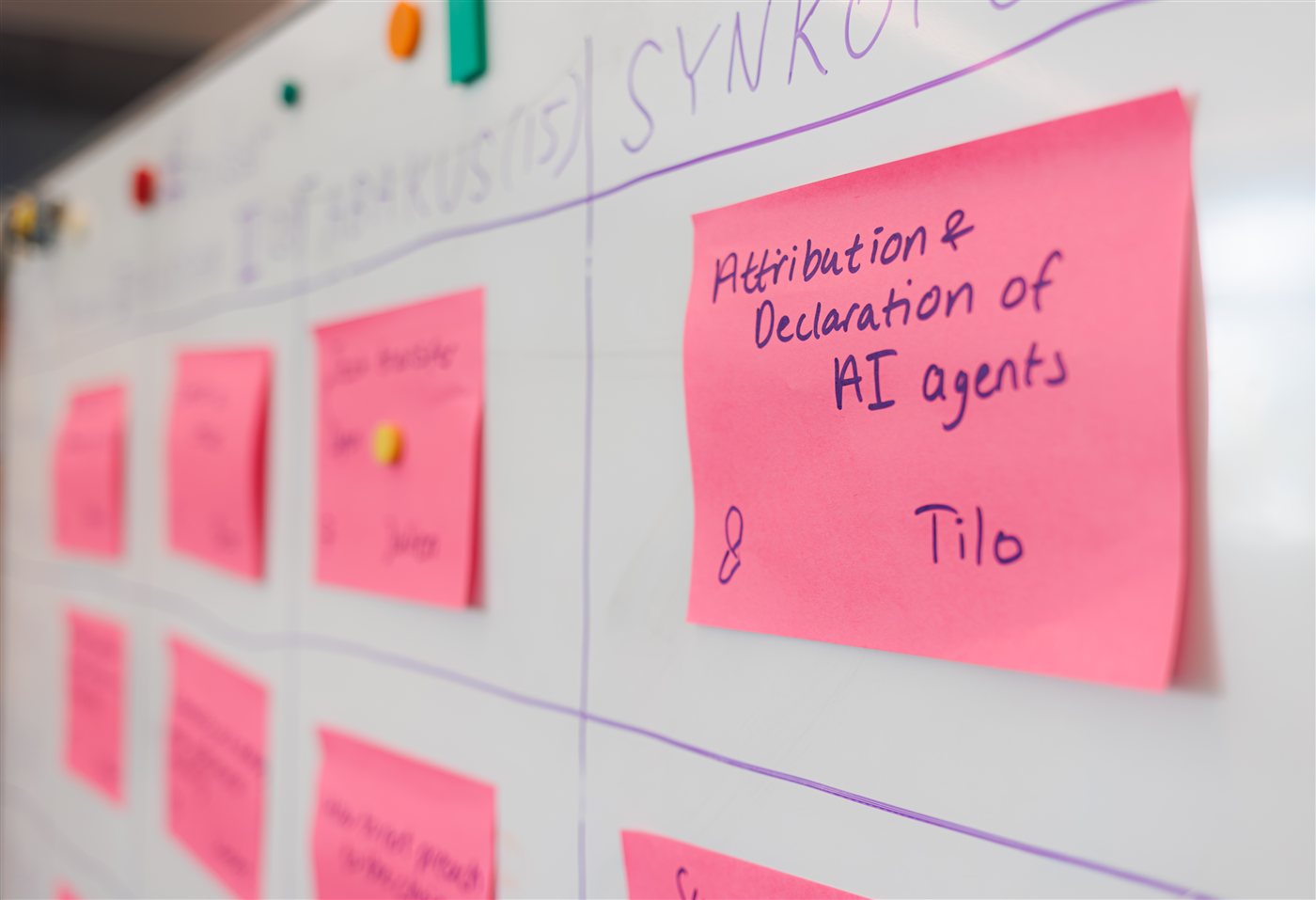 A whiteboard session grid filled with pink sticky notes proposing sessions, one reading 'Attribution and Declaration of AI agents'.
